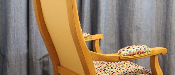 3/4 dos d'un petit fauteuil Voltaire enfant. bois chêne clair. tissu dos micro jacquard jaune / écru. rappel la teinte du bois.