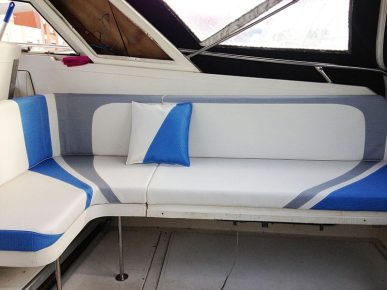 cockpit extérieur d'un bateau moteur. assises et dossiers avec jeu de courbes et de bandes bleues et grises sur fond blanc en simili effet textile